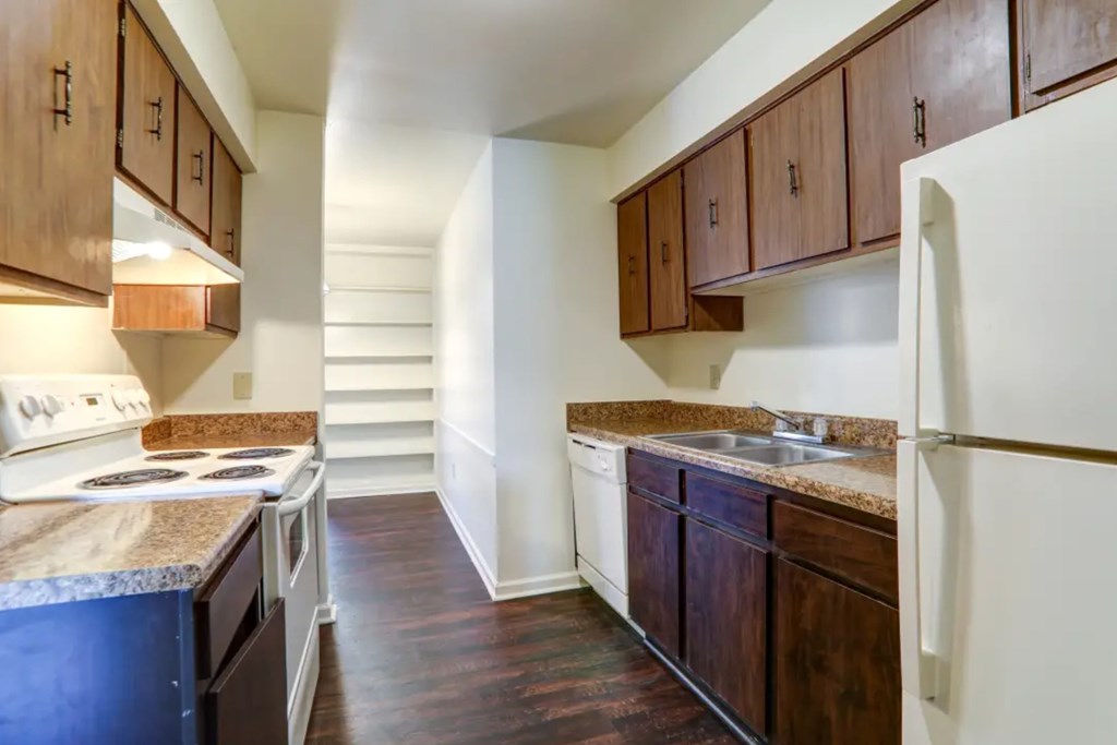 A kitchen with dark wood cabinets and a white refrigerator.
